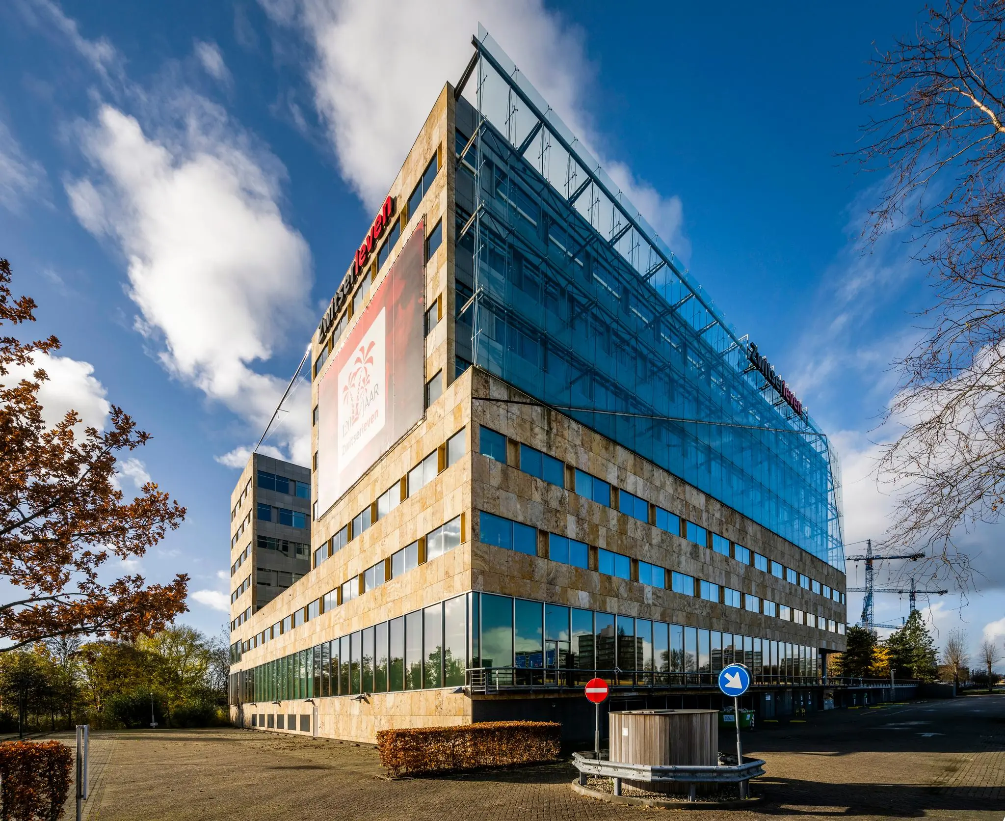 Modern kantoorgebouw aan de Burgemeester Rijnderslaan met glazen gevel en het logo van Zwitserleven.